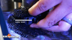 Move the defoaming device up or down until the cage is half way submerged. 